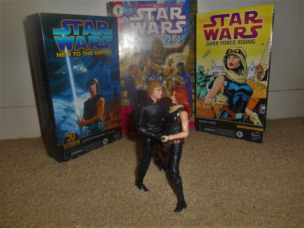 Luke and Mara Jade Action figures with the action figure boxes behind them, with the Thrawn trilogy cover art on them
